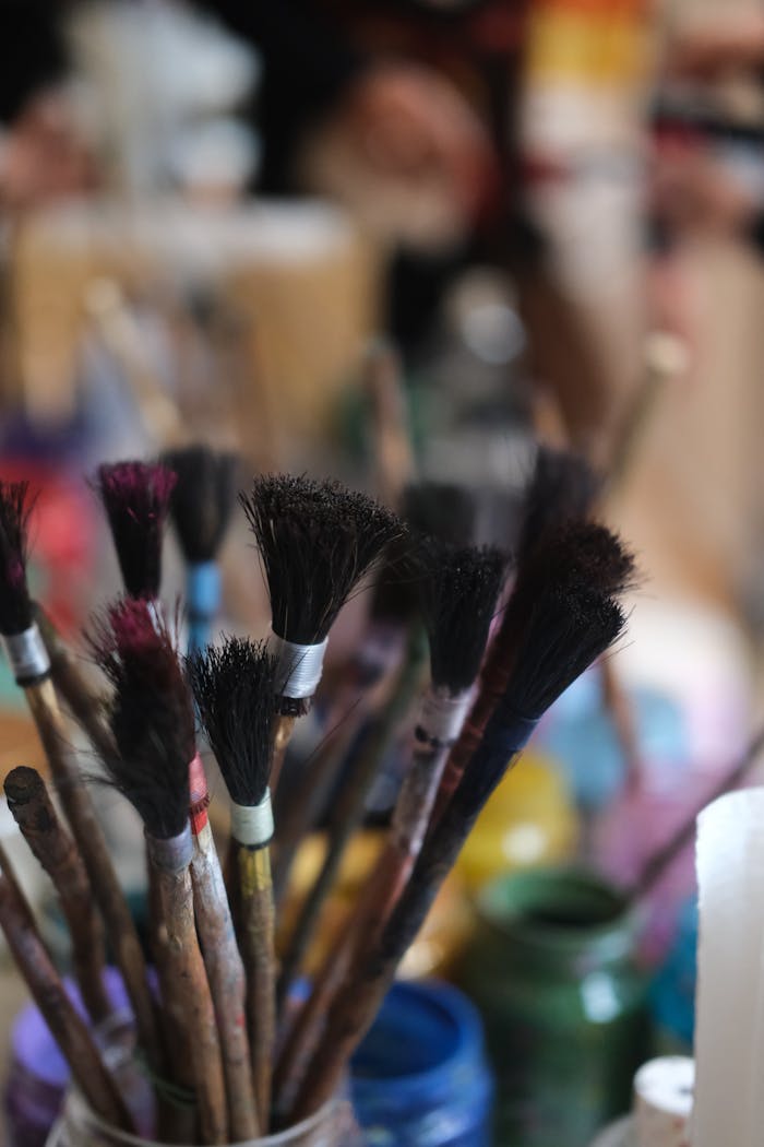 Colorful paintbrushes in jars capturing artistic creativity in a studio.