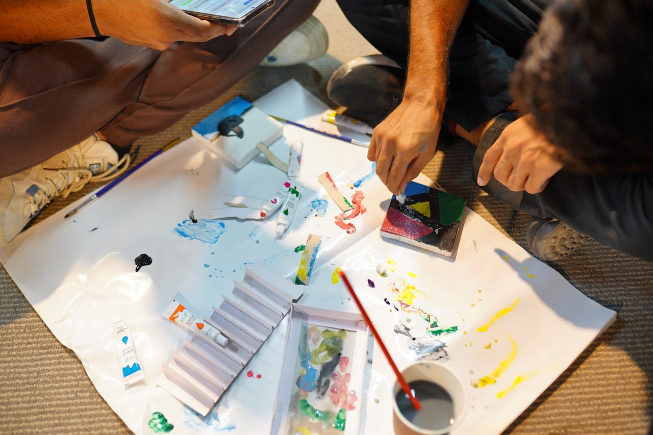 Adults engaged in a hands-on painting workshop, mixing colors and creating art indoors.