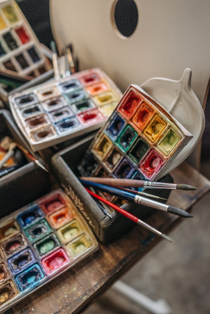 Top view of colorful watercolor paints and brushes, capturing creativity and artistry.
